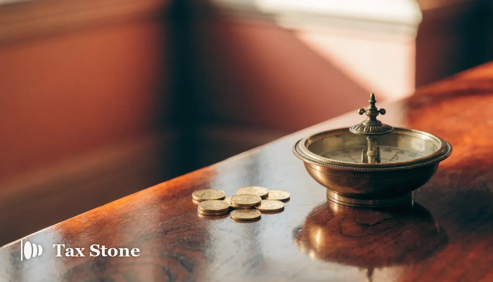TaxStone hero image — an antique brass compass beside gold coins on a mahogany desk, illustrating the UK Temporary Repatriation Facility deadline.