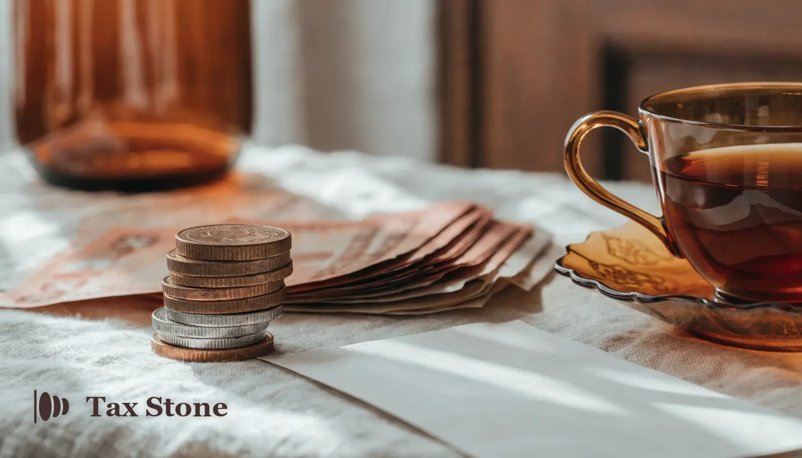 British pound coins and banknotes beside a payslip and a cup of tea — TaxStone UK take-home pay salary calculator